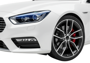 A closeup view of the front corner of a sleek white modern car highlighting the intricate headlight grille and sporty alloy wheel isolated on