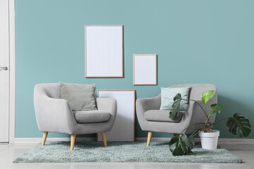 Interior of living room with armchairs, photo frames and houseplant