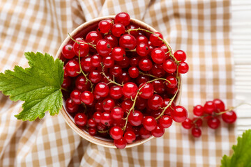 Bowl with fresh red currants on white wooden background, closeup