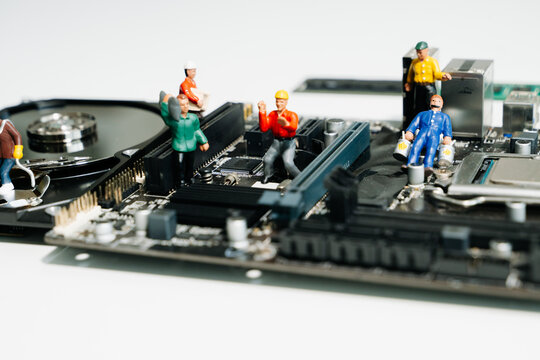 Creative tech concept showing miniature workers repairing an open hard disk drive on a motherboard. Symbolizes data recovery, repair, and computer maintenance. - Powered by Adobe