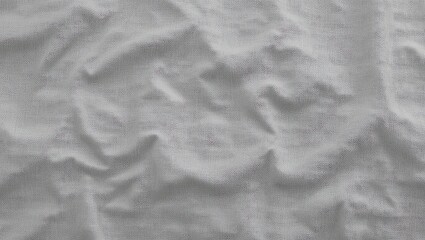 Fototapeta premium A close-up view of wrinkled white fabric displaying texture and depth, perfect for backgrounds and design.