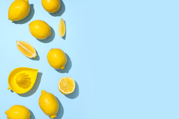 Fresh ripe lemons and juicer on blue background