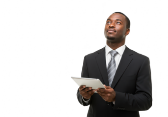 A professional african american businessman in a dark suit and tie holds a tablet and looks upwards thoughtfully contemplating his next business move