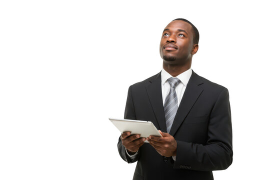 A professional african american businessman in a dark suit and tie holds a tablet and looks upwards thoughtfully contemplating his next business move