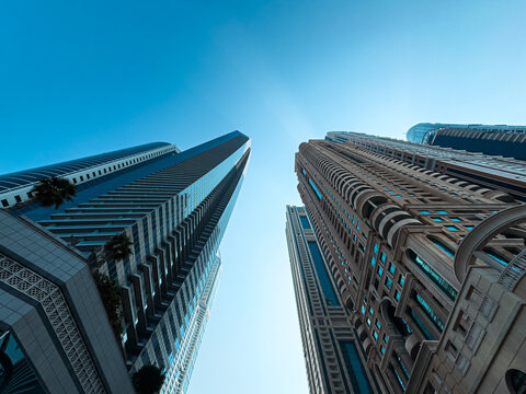 modern building, tall skyscrapers background, looking up into blue sky
