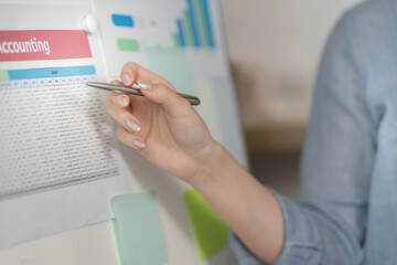 Accounting Overview. Woman pointing at financial data on a chart.