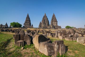 View of Prambanan temple, a UNESCO World Heritage site. Under a brilliant clear blue sky, the massive, intricately carved stone structures rise majestically, located on Klaten, Indonesia.