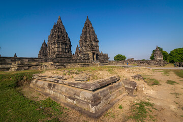 View of Prambanan temple, a UNESCO World Heritage site. Under a brilliant clear blue sky, the massive, intricately carved stone structures rise majestically, located on Klaten, Indonesia.