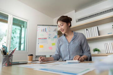 Remote Work. Focused woman writing notes and analyzing data in modern office.