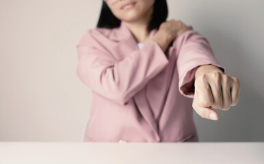 Asian businesswoman has shoulder pain from sitting all day Massage overworked shoulders Health and...
