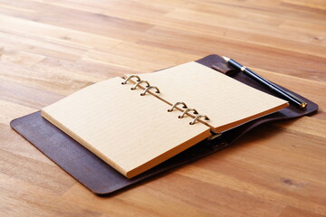 Opened Organizer with Pen on Table
