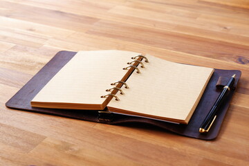 Opened Organizer with Pen on Table
