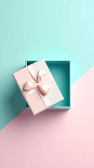 A pastel pink and mint gift box with a pale pink bow sits ajar on a two-toned background