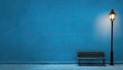 Empty bench and lamp post against a vibrant blue wall