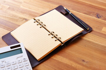 Calculator with opened notebook on table

