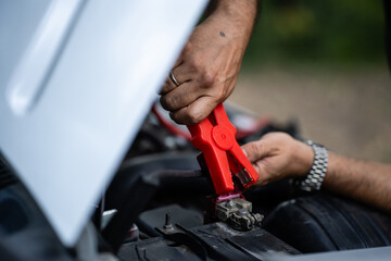 Mechanic using jumper cables to recharge car battery