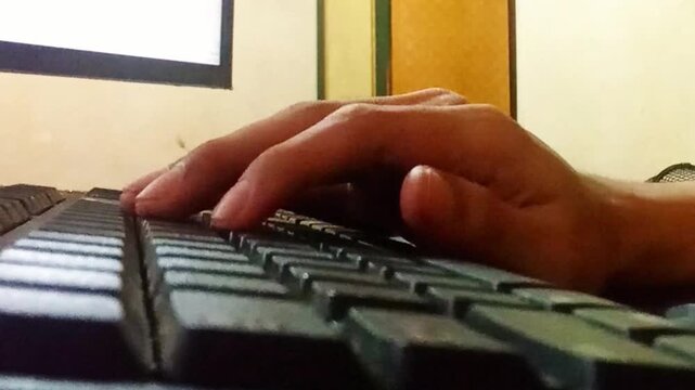 4K horizontal close-up footage of hands typing on a black computer keyboard in an indoor setting. Captured at 60fps with no face visible, ideal for remote work, tech, or office-related themes.