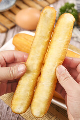Enjoying deep fried crispy fritters for a traditional gourmet breakfast at a bustling local cafe in the morning