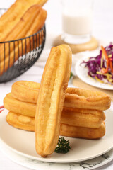 Delicious crispy fritters stacked on a plate with colorful side salad in a warm breakfast setting