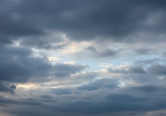 Obraz premium A dramatic and moody sky filled with dark grey and blue storm clouds, suggesting impending weather.