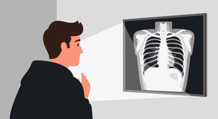 A man in a dark hoodie looks at a chest X-ray of a human rib cage on a light box.