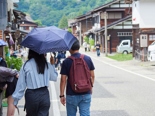 夏の観光地白川郷の街で歩く人々の観光客の姿