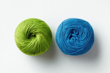 Two balls of yarn, green and blue, on white background