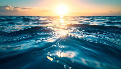 Ocean water surface at sunset with golden sunlight reflections on gentle waves. Calm, serene seascape background perfect for nature, travel, and design projects.