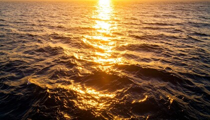 Ocean water surface at sunset with golden sunlight reflections on gentle waves. Calm, serene seascape background perfect for nature, travel, and design projects.