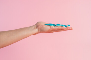 Jelly fish candies. Gummy shark, blue dolphin jelly coated with sugar and hand on a pink background.