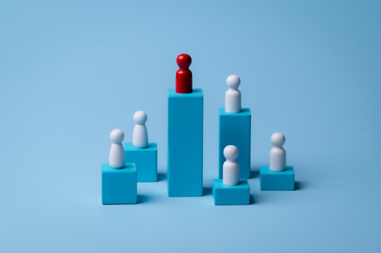 Red wooden figure standing on wooden podium for business leadership for team leader concept.