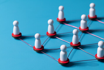 Obraz premium Wooden human figures connected by glowing thread — HR network and team connectivity on blue Background