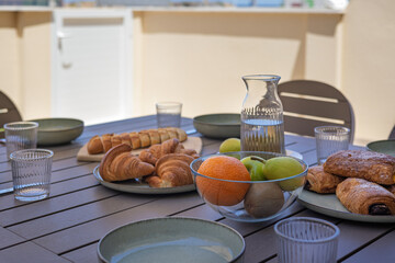 Outdoor Breakfast Spread with Croissants and Fruit