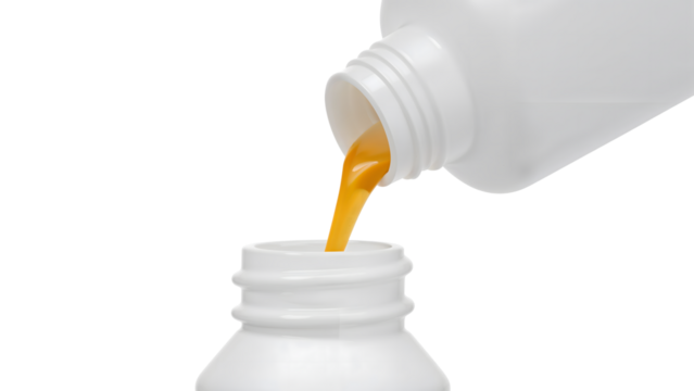 Orange liquid being poured from white plastic bottle into container on the transparent background, closeup of viscous fluid transfer for medical or chemical use