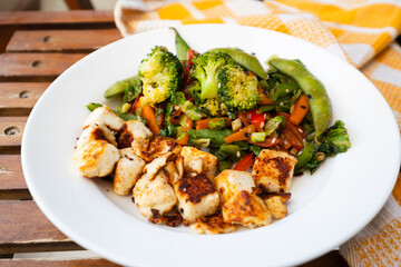 stir fried vegetables and edamame with pan grilled paneer, healthy Vegetarian meal in a white ceramic plate