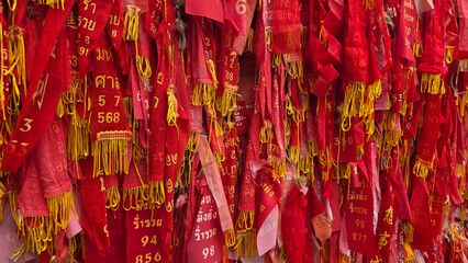 Wall of red prayer ribbons with blessings.