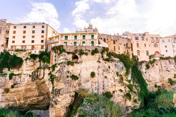 Naklejka premium scenic travel landscape of beautiful historic town Tropea in Italy with old antique buildings, vintage houses on a high rock cliff above sea and amazing blue sky on background
