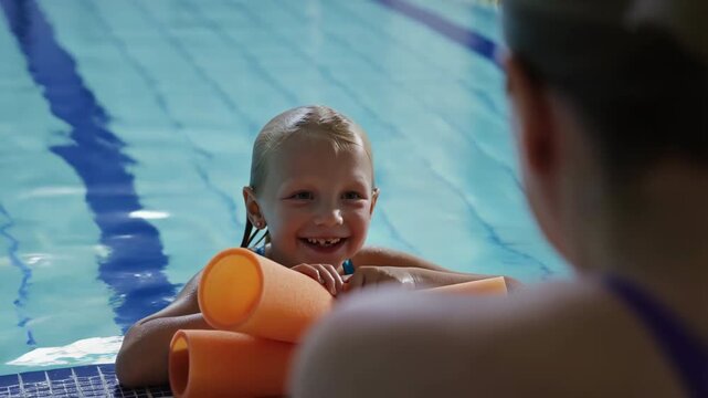Child, swimming lesson and coach in pool with learning, fun and support for water safety, smiling and skill development with teaching, aquatic training and confidence building