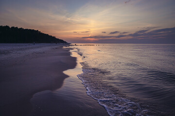 Sunset over sandy beach in Debki resort village on the Baltic Sea coast in Pomerania region of Poland