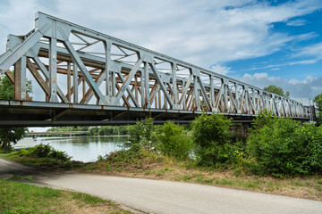 Fototapeta premium Die im Umbau befindliche alte Eisenbahnbrücke zur Fiesta Bridge über den Fluß Waag (Váh) Kulturhauptstadt 2026, Trenčín, Slowakei