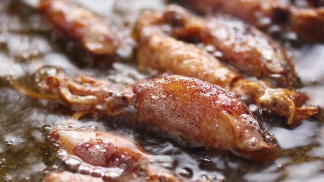 Fried dried cuttlefish (Beka squid) in boiling oil. Close-up shot
