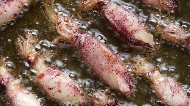 Fried dried cuttlefish (Beka squid) in boiling oil. Top view shot