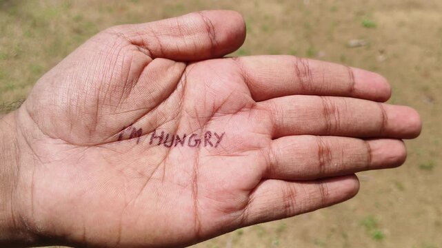 I'm hungry word or text written on starving poor refugee or homeless adult person palm. Hunger, poverty, ravenous, starving, famin, starvation, food crisis and begging concept.