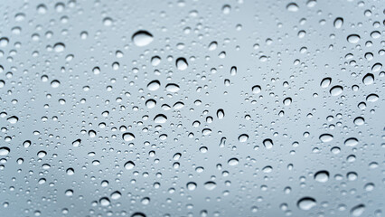 This image showcases the intricate textures formed by numerous water drops on a smooth glass plane,...