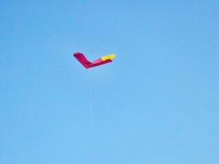 Kites in mid-flight under clear sky highlight movement and joy, great for leisure campaigns, outdoor lifestyle, or family moments