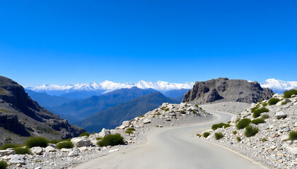Winding mountain road with rocky terrain and snow.


