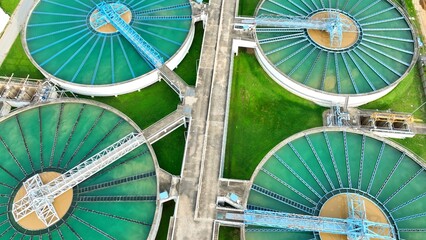 Drone shot of a modern wastewater treatment plant featuring sedimentation tanks and filtration systems, emphasizing infrastructure designed to treat and recycle water efficiently and safely.  © Punyawee
