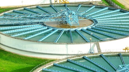 Bird's eye view of a wastewater treatment facility with circular clarifiers and rectangular filtration basins, showcasing critical infrastructure for effective water purification and community health.