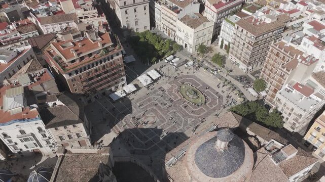Descenso a&eacute;reo con dron en contrapicado centrado sobre la Plaza de la Virgen en Valencia, revelando edificios del casco antiguo