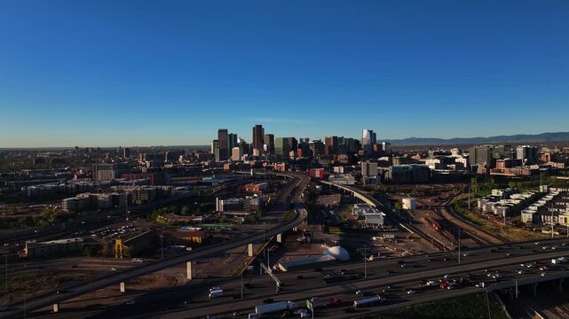 Aerial view of Denver's skyline with roads bustling with vehicles under a clear sky, a vibrant urban landscape, Denver, Denver County, United States.